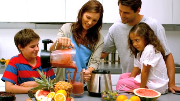 Mulher com família derramando coquetel de frutas de um liquidificador — Vídeo de Stock