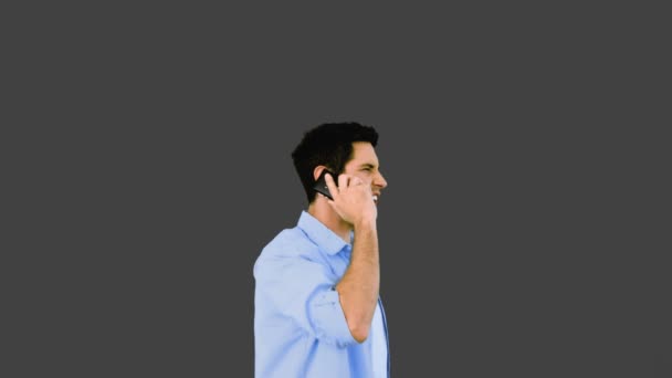 Irritado homem falando no telefone e jogá-lo fora no fundo cinza — Vídeo de Stock
