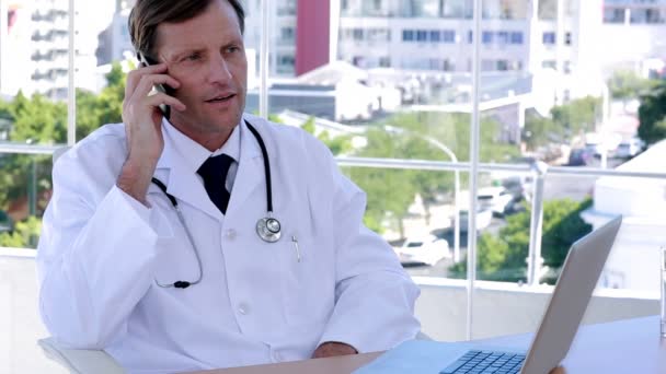 携帯電話とラップトップに取り組んでいる医者 — ストック動画