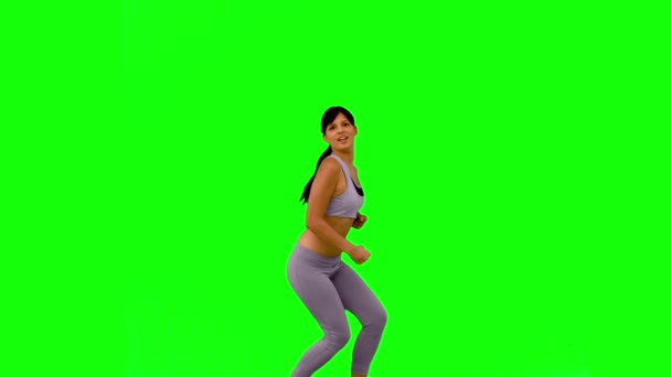 Athletic woman jumping and posing on green screen — Stock Video
