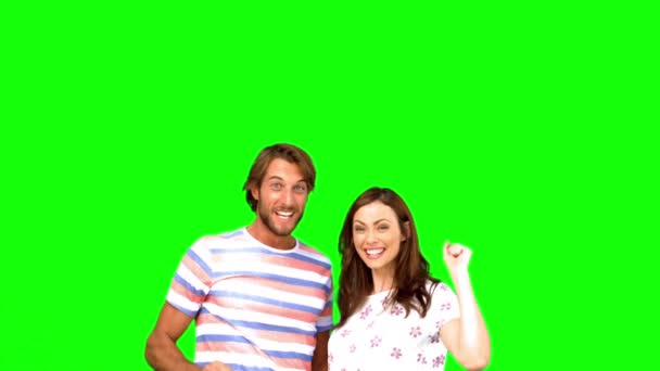 Two friends raising their arms on a green screen — Stock Video