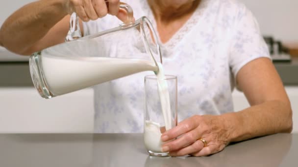 Frau schenkt Glas Milch ein — Stockvideo