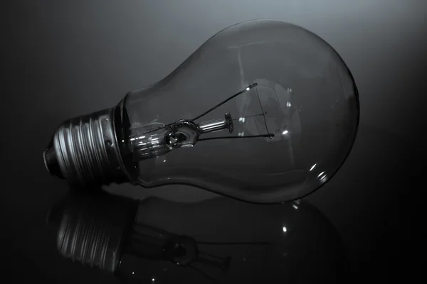 Clear light bulb laying on its side in black and white — Stock Photo, Image