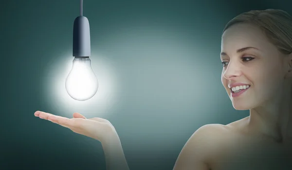 Woman presenting light bulb — Stock Photo, Image