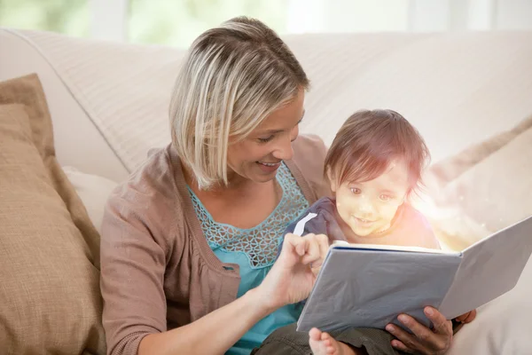 Mother and her son reading a glowing story together — Stock Photo, Image