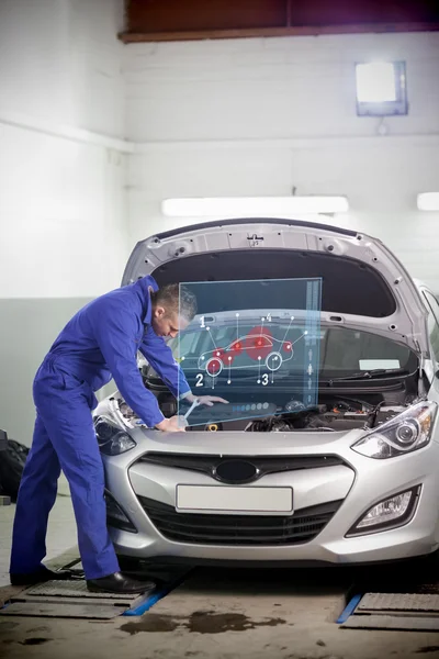 Man repairing car with open hood and small futuristic interface — Stock Photo, Image