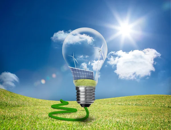 Light bulb showing solar panels and turbines in a field — Stock Photo, Image