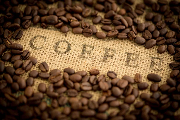 Grãos de café em torno de café estampado no saco — Fotografia de Stock