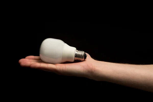 Mão segurando lâmpada econômica — Fotografia de Stock