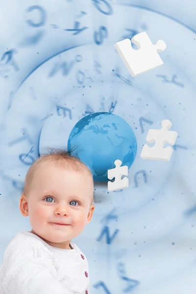 Portrait of a baby with globe and jigsaw pieces background — Stock Photo, Image
