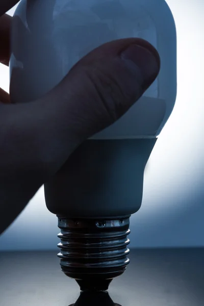 Hand holding an economic light bulb — Stock Photo, Image