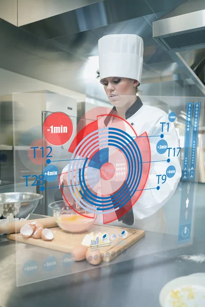 Pastry chef making dough while consulting futuristic interface — Stock Photo, Image