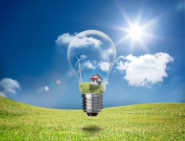 Light bulb showing house and turbines in a field — Stock Photo, Image