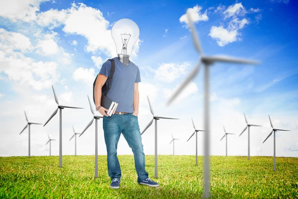 Student with a light bulb head in the middle of wind turbine fie — Stock Photo, Image