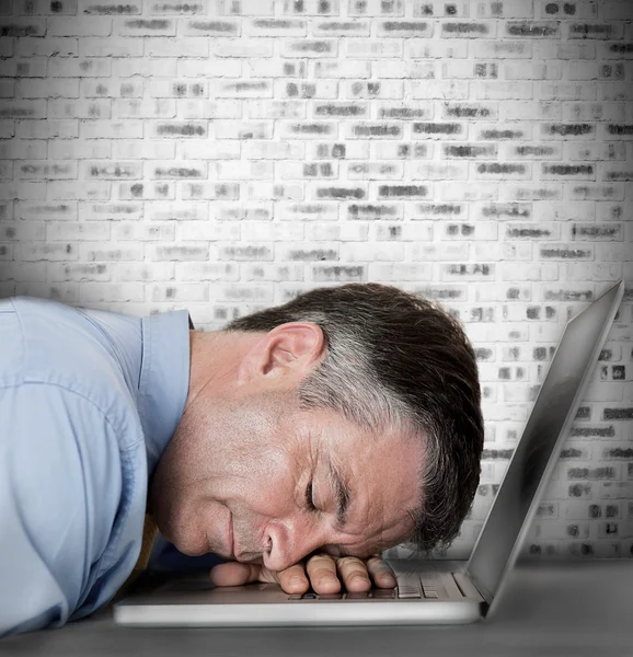 Businessman sleeping on his laptop Stock Photo