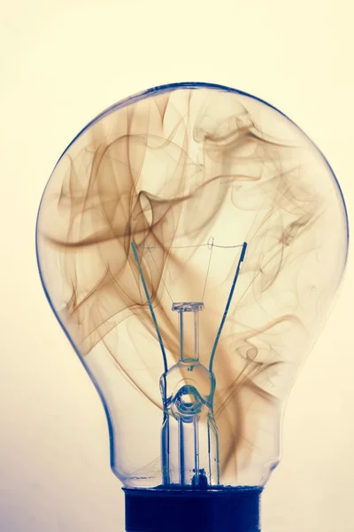 Primer plano de la bombilla de luz clara con humo en el interior —  Fotos de Stock