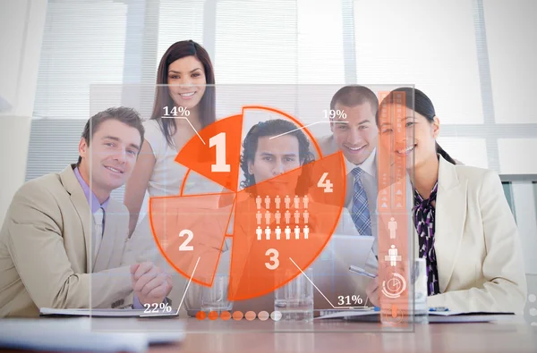 Smiling business workers looking at orange pie chart interface — Stock Photo, Image