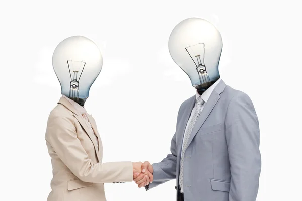Negócio com cabeças de lâmpada saudação com um aperto de mão — Fotografia de Stock