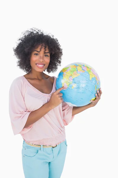 Frau hält Globus und zeigt auf ihn — Stockfoto
