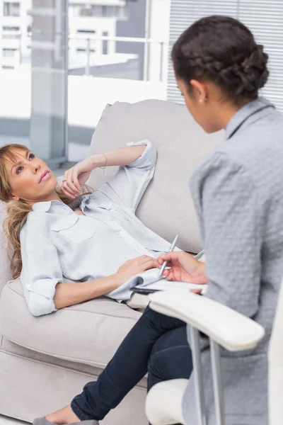 Donna sdraiata sul divano dei terapisti guardando in alto — Foto Stock