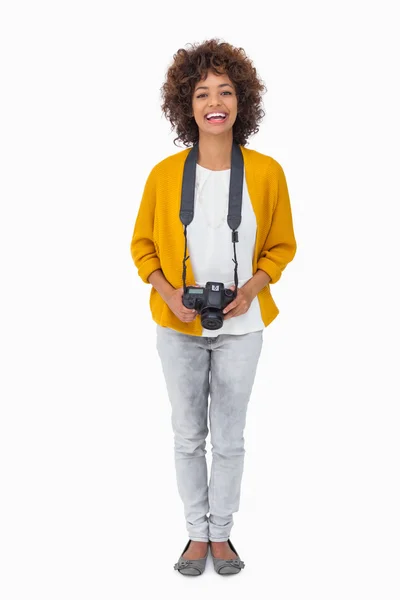 Смолящая девушка держит цифровой фотоаппарат и смотрит в камеру — стоковое фото
