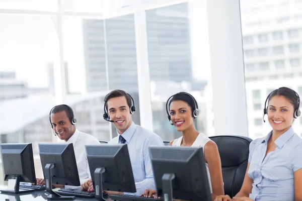 Lijn van call centrum medewerkers glimlachen — Stockfoto