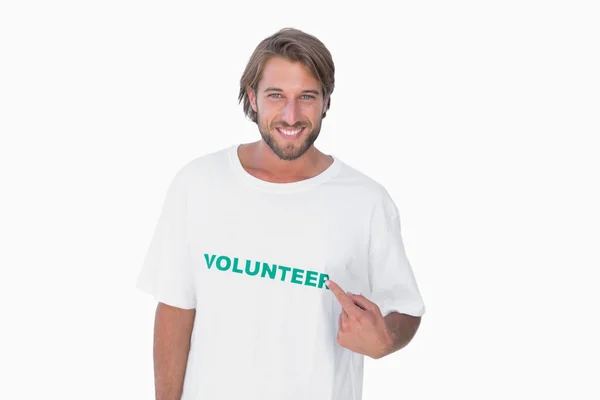 Sonriente hombre señalando a su camiseta voluntaria — Foto de Stock