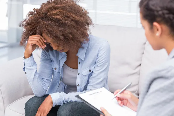 Woman sitting on sofa and crying in therapy — Stock Photo, Image