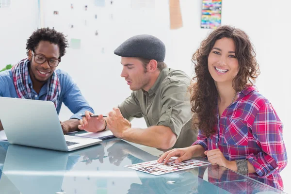 Equipo creativo trabajando junto con uno sonriendo a la cámara —  Fotos de Stock