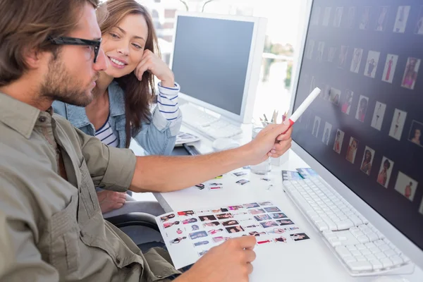 Photo editor pointing at thumbnail on screen — Stock Photo, Image