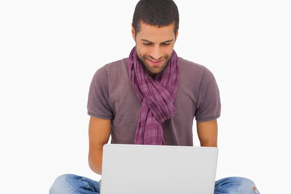 Fashionable man sitting on floor using laptop — Stock Photo, Image