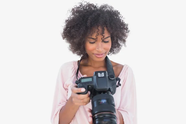 Счастливая женщина смотрит на цифровую камеру — стоковое фото