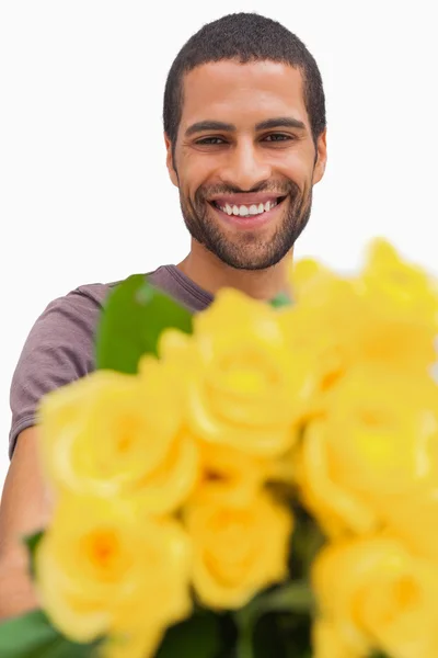 Bonito homem oferecendo um monte de rosas amarelas — Fotografia de Stock