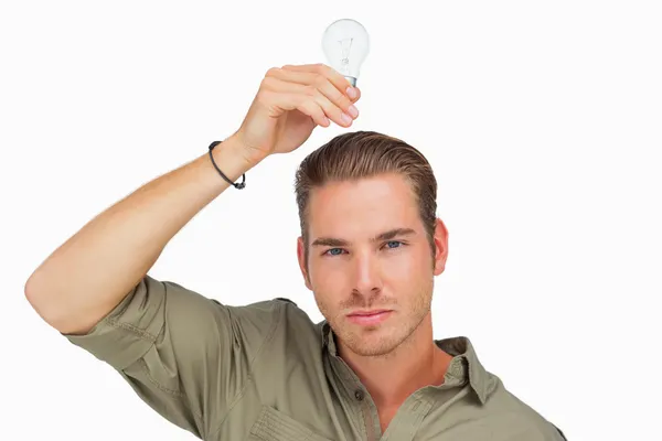 Man holding light bulb above his head — Stock Photo, Image