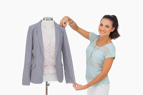 Modeontwerper meten blazer mouw op mannequin en glimlachen — Stockfoto