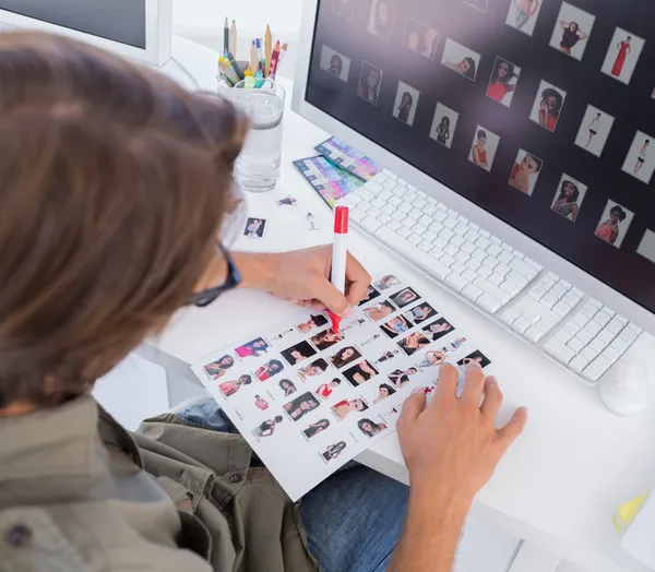 Over head of editor marking contact sheet — Stock Photo, Image