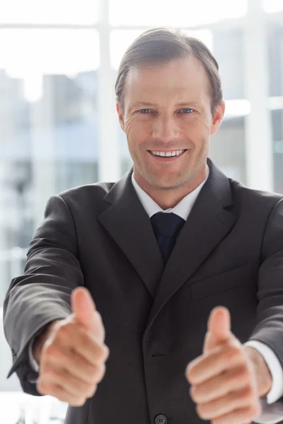 Улыбающийся уверенный бизнесмен, показывающий большие пальцы — стоковое фото