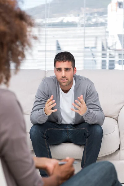 Homem perturbado falando com um terapeuta — Fotografia de Stock