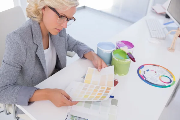 Diseñador de interiores rubio concentrado sosteniendo cartas de colores — Foto de Stock