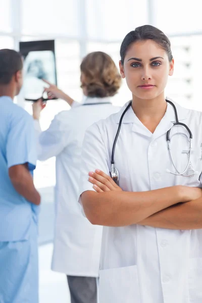Seriös kvinna läkare med armar korsade tittar på kameran — Stockfoto