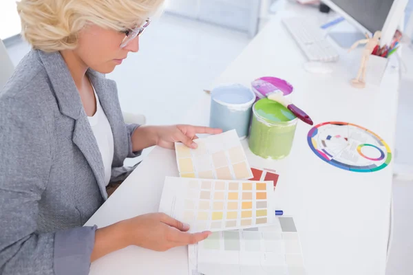 Serious interior designer looking at colour charts — Stock Photo, Image