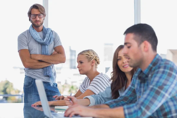 Man standing with arms folded in creative office — Stock Photo, Image