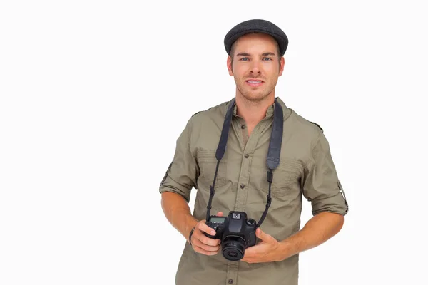 Homem de boné de pico segurando câmera — Fotografia de Stock