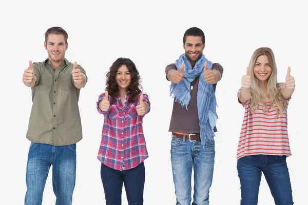 Fashionable friends looking at camera and giving thumbs up — Stock Photo, Image