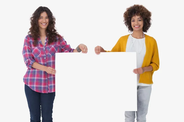 Aantrekkelijke vrouwen houden van lege kaart en kijken naar camera — Stockfoto