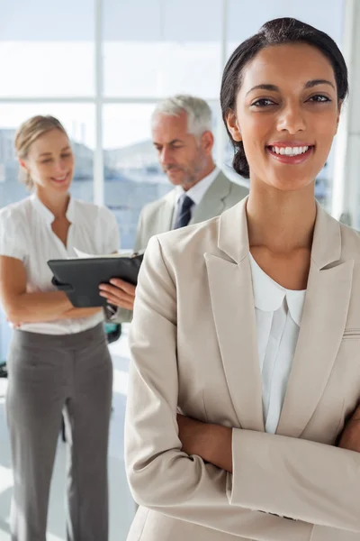 Orgullosa mujer de negocios frente a colegas que trabajan detrás — Foto de Stock