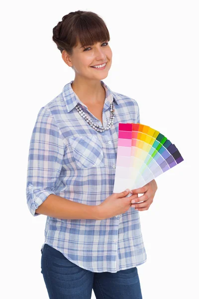 Pretty woman with fringe holding colour charts — Stock Photo, Image