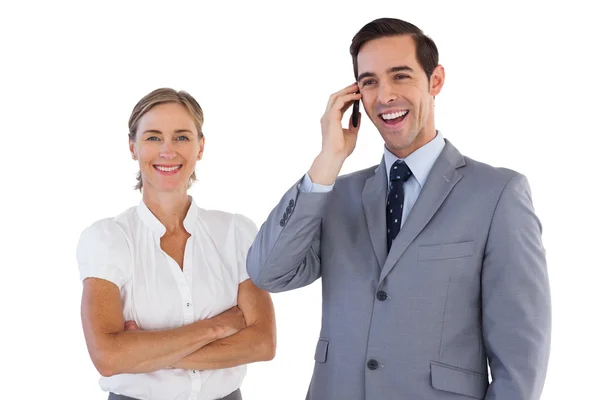 Χαμογελώντας επιχειρηματίας στο τηλέφωνο δίπλα στο συνάδελφο — Φωτογραφία Αρχείου