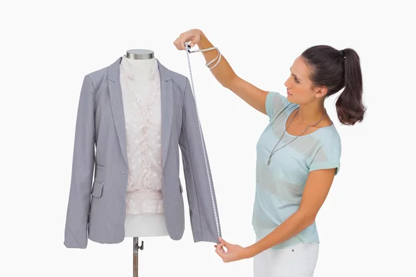 Fashion designer measuring blazer sleeve on mannequin — Stock Photo, Image