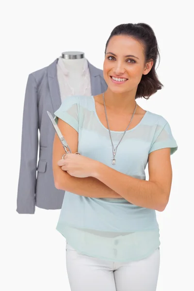 Designer holding scissors in front of mannequin — Stock Photo, Image